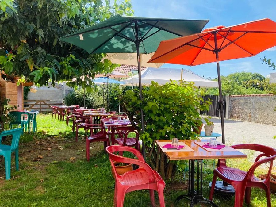 Terrasse jardin ensoleillée du Relais d'Uriage, parasols colorés
